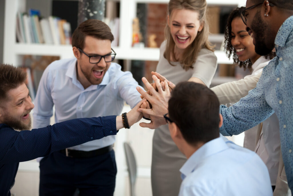 Excited motivated multi-ethnic team people give high five, happy diverse office employees executive group celebrate corporate success, sharing victory, engaged in unity support teambuilding concept