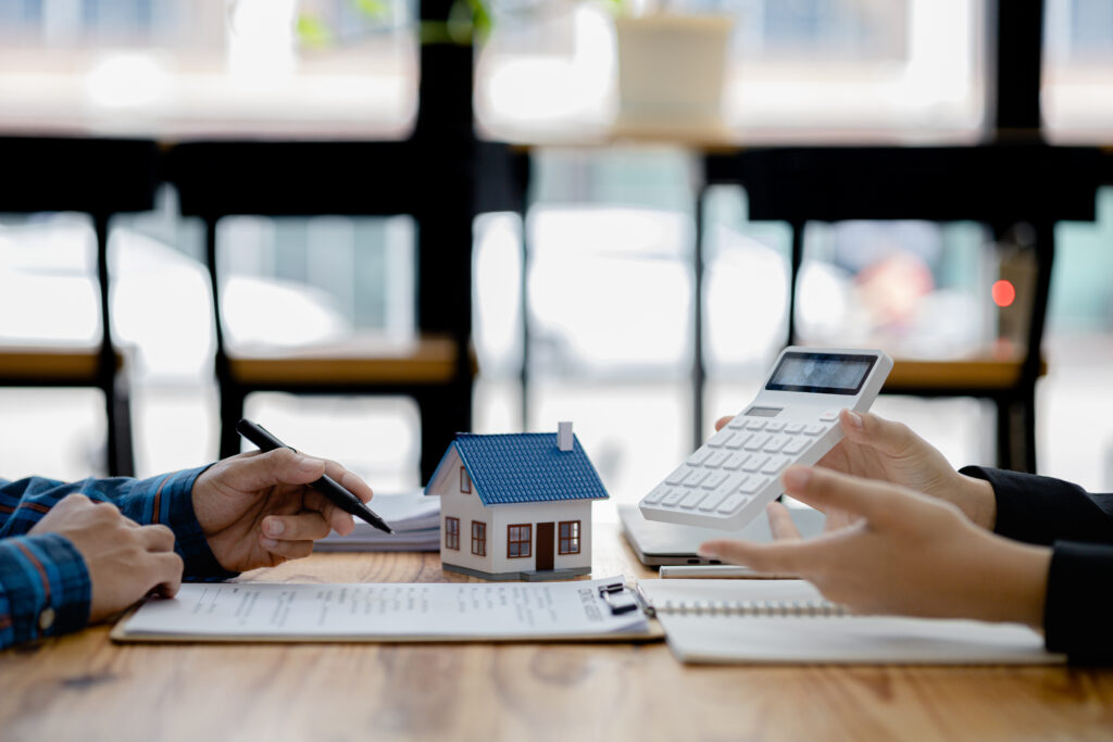 Real estate agents explain models of housing estates in projects to elaborate to clients, explaining and presenting information about homes and purchasing loans. Real estate trading concept.