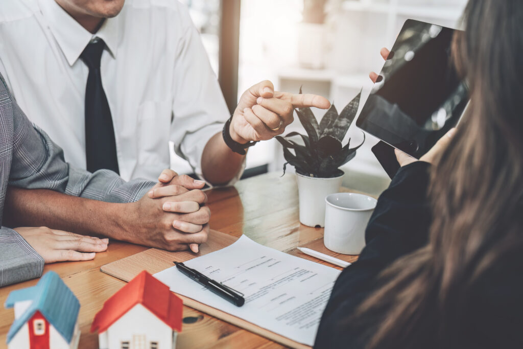 Bank officer, real estate employee talking to spouse, see information in Tablet computer about interest rates for home loan in the office, loan, insurance, financial risk management concepts.